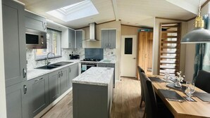 A compact kitchen with grey cabinets, a microwave, and a central island. - Host Stay Coopers Corner (York)