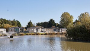 A residential area with houses along a water body, surrounded by trees and vegetation. - Host Stay Ailsa Lodge (York)