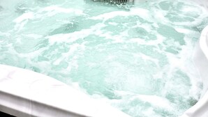 A hot tub with a visible drain and water jets. - Host Stay Ailsa Lodge (York)