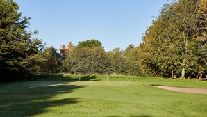 A golf course with a clear sky, well-maintained grass, and trees in the background. - Host Stay Ailsa Lodge (York)