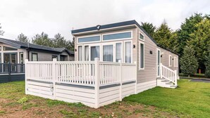 A mobile home with a deck and a staircase leading to the entrance. - Host Stay Lakeside Retreat (York)