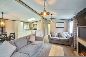 A modern living room with a fireplace, a dining area, and a kitchen in the background. - Host Stay Lotus Lodge (York)