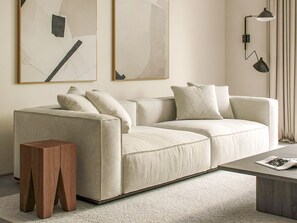A modern living room with a beige sofa, a wooden side table, and a floor lamp. - Sanders Soul Apartments - Full Building (Limassol)