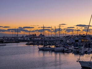 Un puerto deportivo con varias embarcaciones fonqueadas al atardecer.