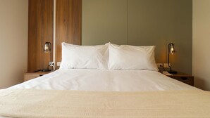 A neatly made bed with white linens, two bedside lamps, and a wooden panel on the wall. - w Lovely 2BR w Balcony in Miraflores (Lima)