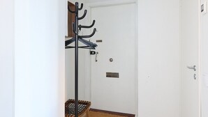 A hallway with a coat rack, a door, and a light fixture. - Beautiful Studio in Middle of Downtown (Turku)