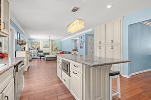 A spacious kitchen with white cabinetry, a granite countertop, and a central island. - Spacious 4BR Family Retreat w Private Pool (Cerritos)