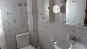 A bathroom with a toilet, sink, and mirror. - Couples Warm Nook - Thassos Seabreeze Nest (Thasos)