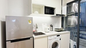 A compact kitchen with a stainless steel refrigerator, a microwave, a washing machine, and a sink. - Luxury Brand-new Apt in Low-Density Villa, Pool View near the Old town & Airport (Pa Daet Sub District , Mueang District)