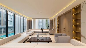 A modern living room with a sofa, armchairs, a coffee table, and a bookshelf. - Luxury Brand-new Apt in Low-Density Villa, Pool View near the Old town & Airport (Pa Daet Sub District , Mueang District)