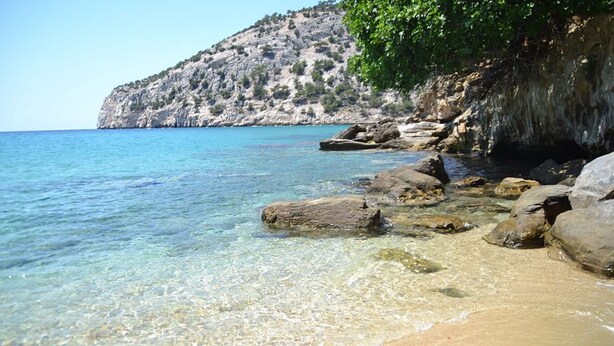 A clear coastal beach with rocky formations and a mountainous backdrop. - Anatoli Garden View - Cozy Thassos Getaway (Thasos)