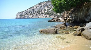 A clear coastal beach with rocky formations and a mountainous backdrop. - Swallow s Nest - Thassos Stylish Escapade (Thasos)