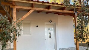Un edificio con una porta bianca, una piccola finestra e un ingresso in pietra.