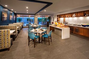 Een modern restaurant met zitjes, tafels, een bar en uitzicht op de omgeving.