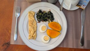 A plate with an omelette, spinach, and sweet potato slices. - Kili Haven Lodge (Moshi)