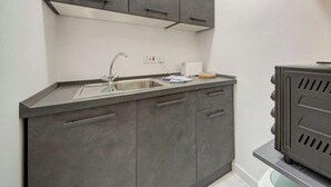 A compact kitchen with a stainless steel sink, a built-in stove, and a small countertop. - Bright Msida Studio · King Bed - Fast WiFi (Msida)