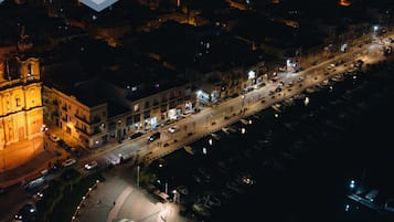 Ett flygbildsbild av en stadsgata på natten, med byggnader, bilar och en framträdande kyrka.