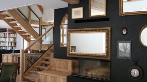 Une pièce avec un escalier en bois, une cheminée et une bibliothèque.
