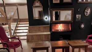 Un salon chaleureux avec une cheminée, des meubles en bois et un escalier.