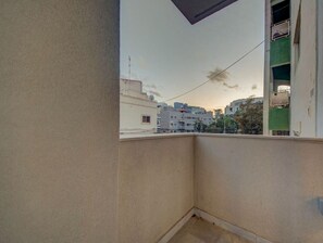 Uma varanda com vista para edifícios próximos e um céu limpo.