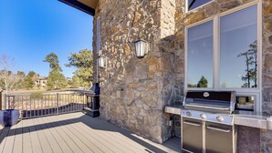 A stone exterior wall with a built-in grill and outdoor lighting. - Hot Tub & Games Galore! Colorado Springs Retreat (Colorado Springs)