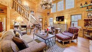 A spacious wooden cabin with a large living area, a staircase, and a kitchen. - Creekside Cabin in the Heart of Maggie Valley (Maggie Valley)