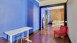 Una habitación con un escritorio blanco, una silla roja y una pared azul.