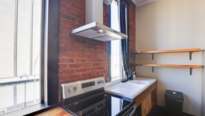Una cocina con estufa, horno y ventana con vistas.
