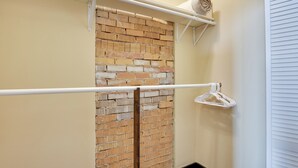 Un baño con pared de ladrillo, toallero y una toalla blanca.