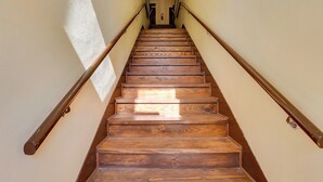 Una escalera de madera con barandillas a cada lado, que conduce a un piso superior.