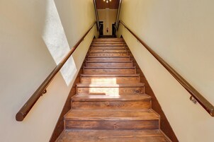 Una escalera de madera con barandillas a cada lado, que conduce a un piso superior.