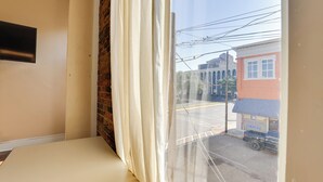 Una habitación con un ventanal grande, una pared de ladrillo y un televisor de pantalla plana montado en la pared.
