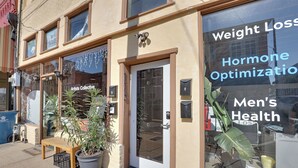A storefront with a sign for 'Weight Loss, Hormone Optimization, Men's Health'. - Shop, Dine & Unwind at Historic Dtwn Marshall Apt (Marshall)