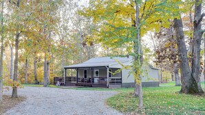 A cabin with a porch, surrounded by trees with autumn foliage. - Walk to Marina & Beach: Charming Home in Hardin (Hardin)