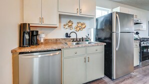A modern kitchen with stainless steel appliances, white cabinetry, granite countertops, and decorative wall art. - 6 Mi to Mammoth Cave! Mtn-view Home w/ Fire Pit (Cave City)