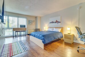 A bedroom with a bed, bedside tables, a desk, and a chair. - Near Stadiums, Parks & Hospitals: Detroit Studio (Detroit)