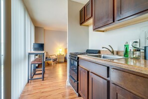 A modern kitchen with wooden cabinets, a built-in oven, and a stainless steel sink. - Near Stadiums, Parks & Hospitals: Detroit Studio (Detroit)