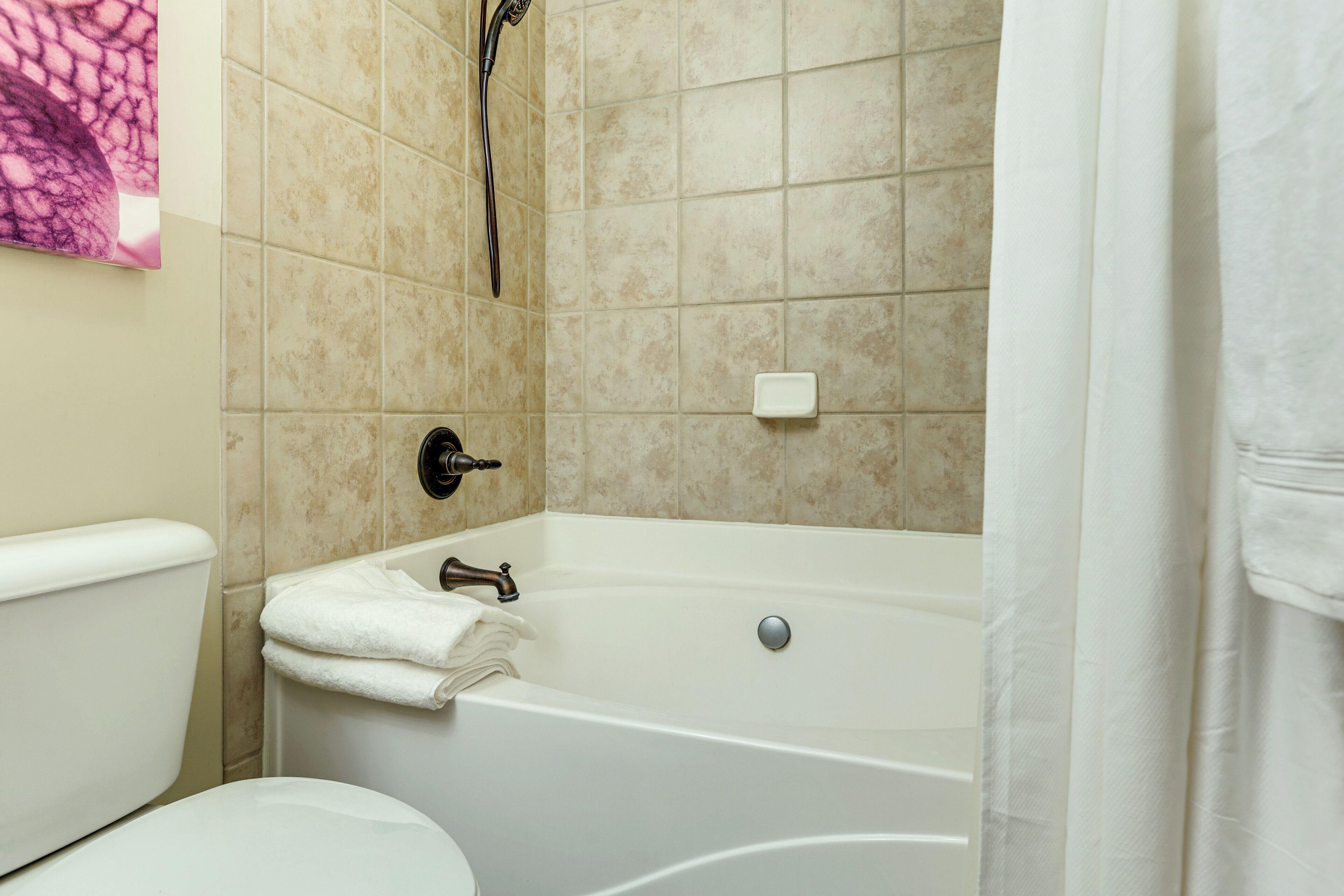 A bathroom with a bathtub, toilet, and a shower.