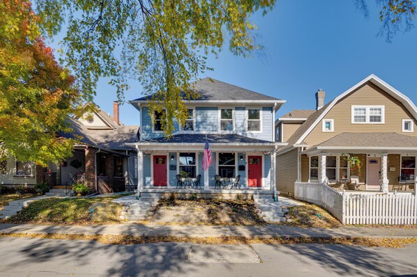A two-story house with a front porch, a picket fence, and a small garden area. - 3 Mi to Dtwn Indy: Urban Retreat w/ Outdoor Space (Indianapolis)