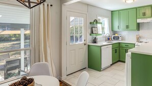 A kitchen with green cabinets, a white countertop, and a window overlooking a balcony. - 2 Blocks to At&t Stadium: Sports Fan Headquarters! (Arlington)