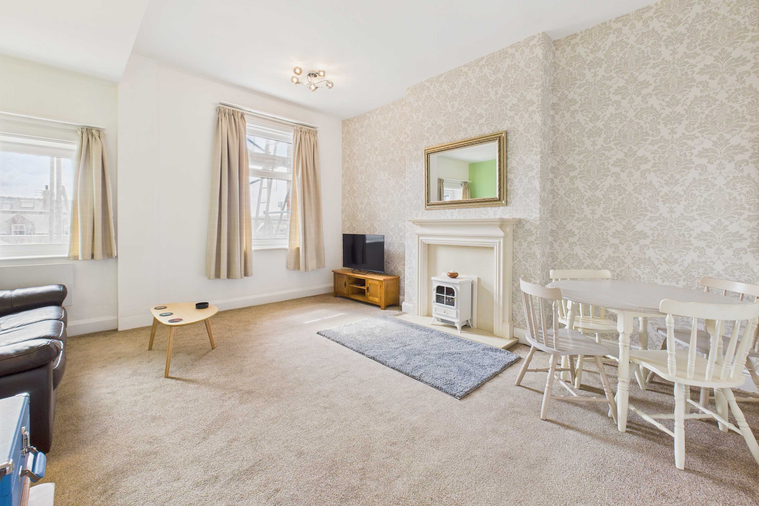 A living room with a fireplace, a dining table, and a sofa.
