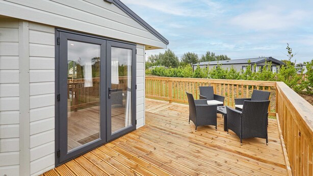 A deck with outdoor furniture and a sliding glass door leading to a room. - Host Stay Deer View Lodge (Pickering)