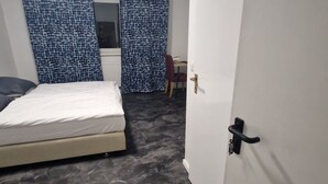 Ein Schlafzimmer mit Bett, Schreibtisch und Stuhl.