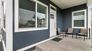 A building with large windows, a door, and a porch with three chairs. - 2 Bed MIL unit with Lake Washington views (Seattle)