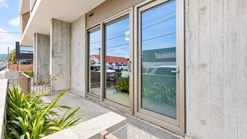 A building with large glass doors, a concrete facade, and a parking lot visible through the windows.