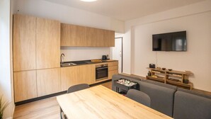 Una cucina moderna con mobili in legno, un tavolo da pranzo e un forno integrato.