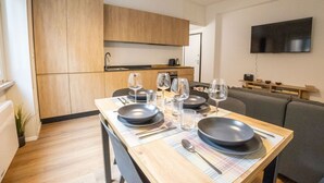 Una cucina moderna con mobili in legno, un tavolo da pranzo apparecchiato con piatti, bicchieri e posate.