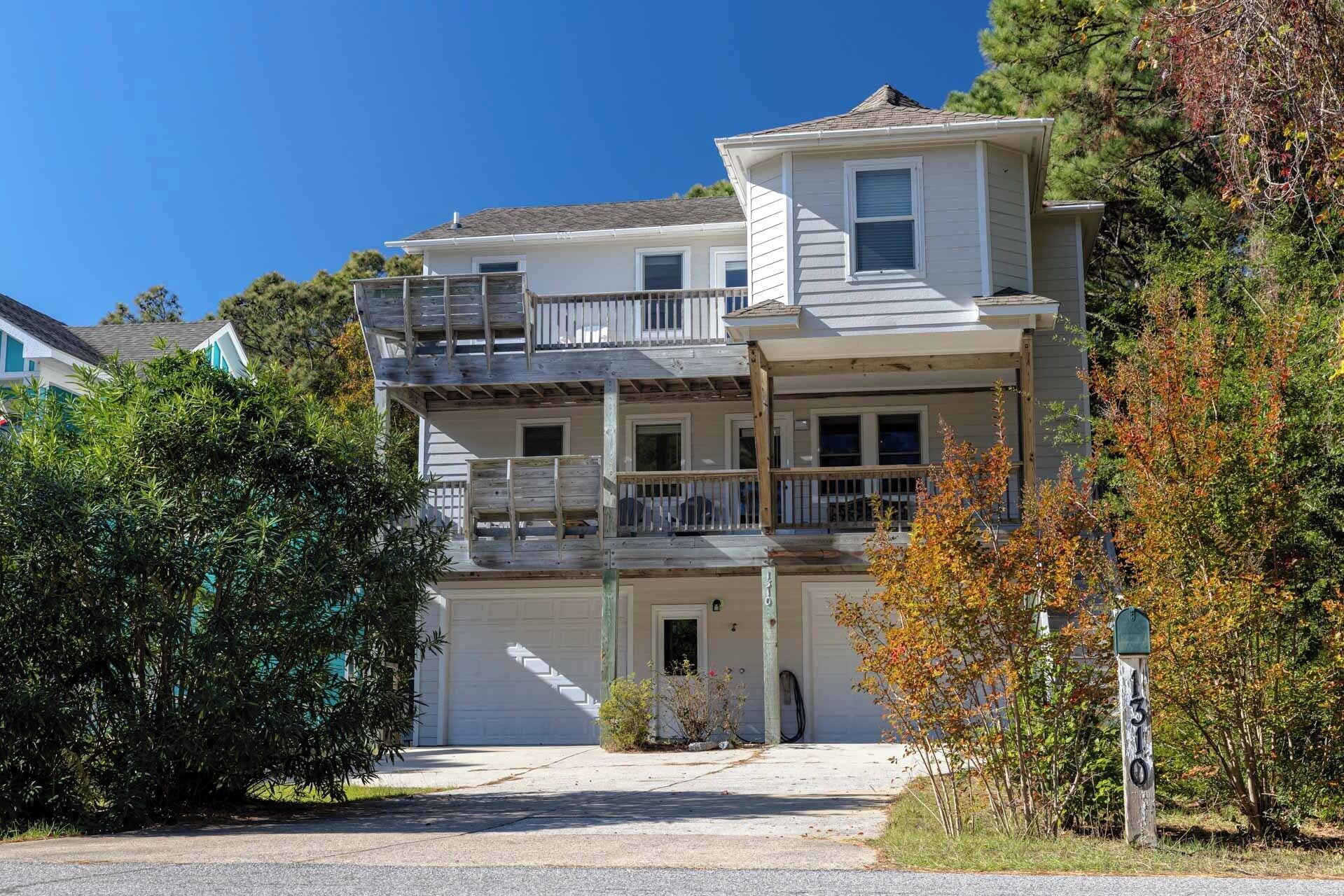 A two-story house with a front porch, a garage, and a balcony.