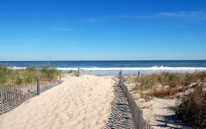 A sandy beach path leading to the ocean, bordered by a wooden fence and vegetation. - Family Vacation! Lovely 4 BR in Canal Corkan-Pool Cmty - 26 Eleanor Lee Ln (Rehoboth Beach)