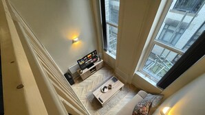 Un salon moderne avec un canapé, une table basse et un téléviseur.
